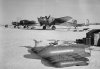 Fyra stycken flygplan B 18B på ett flygfält, vintertid. I förgrunden ligger hängbomber på m.JPG
